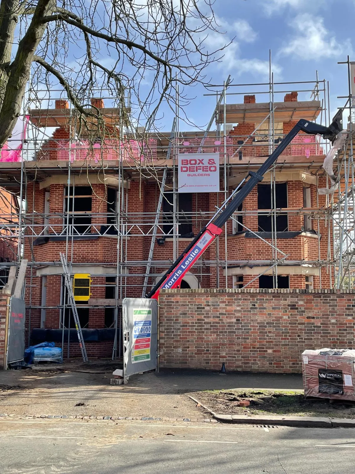 crane working on a building with scaffolding around it