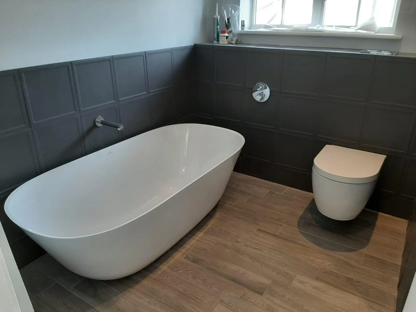 A white bath tub sitting next to a toilet in a bathroom.