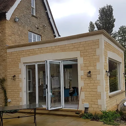 A patio with a table and chairs in front of a house.