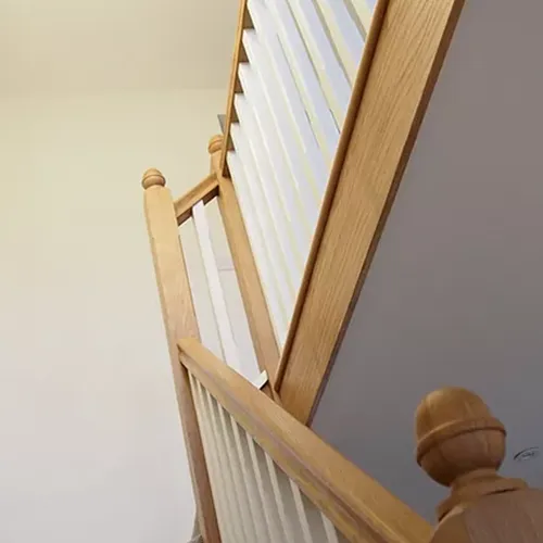 A close up of a wooden stair railing.